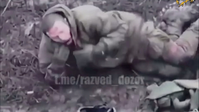 一名受伤的俄罗斯士兵被弹片炸伤后，脱下背心，点燃了一支香烟。