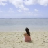 【高清视频素材】美女坐在海边吹风