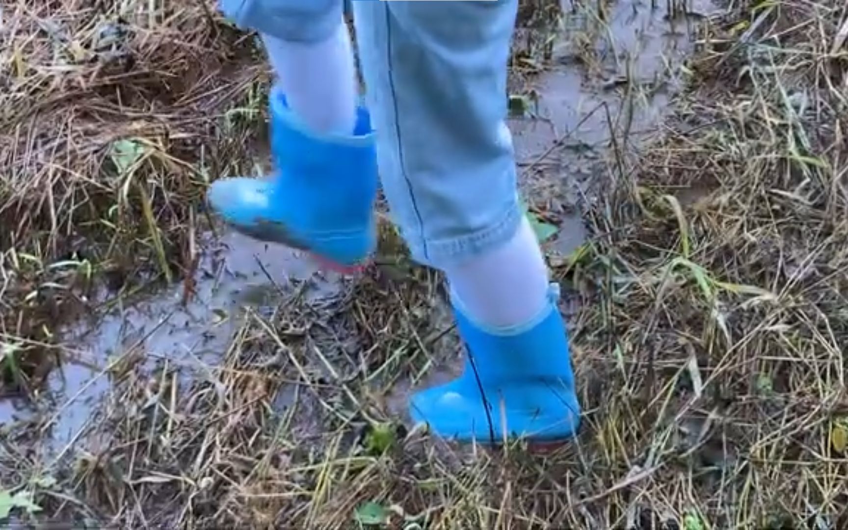 泥泞坑洼里的孩子们穿靴子 Colorful Winter Outdoor Rain Shoes on Childrens Feet in ...