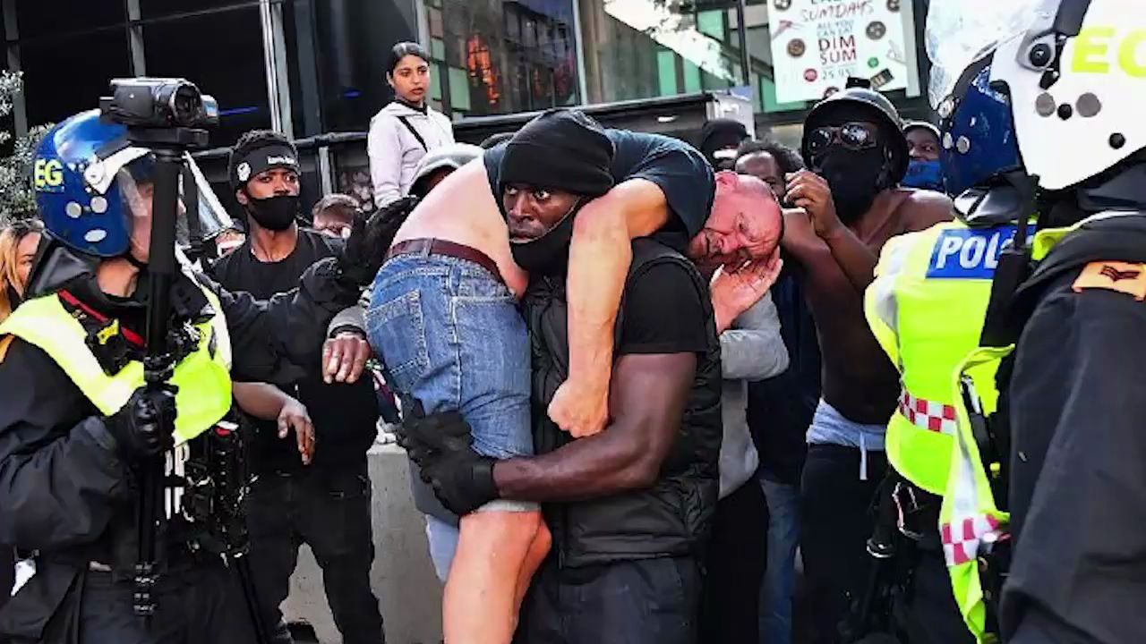 如何评价：英白人男子抗议中受伤 黑人男子出手相救扛着其离开：我不想他死[一阶段]的第1张示图