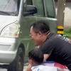 爸爸和儿子下雨天蹲在路边求被溅水