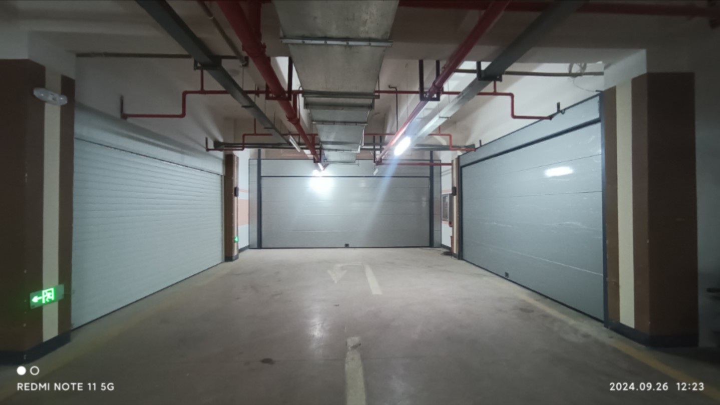 地下车库端头，看到三户人家的车库门，两家是翻板门，另一家是卷帘门。翻板门一看就是大品牌，卷帘门一看就是便宜货。住在同样的小区，人与人之间的差距一目了然。
