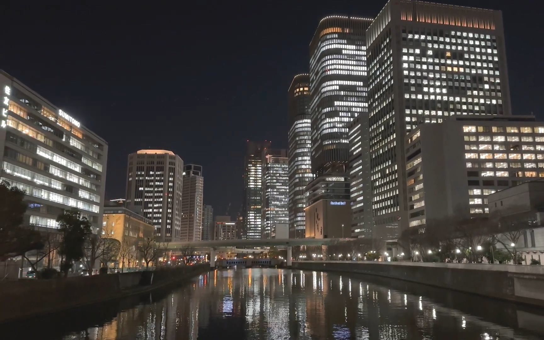 夜晚從中之島區到梅田區街道散步 人工湖水面大阪城市夜景燈光倒影