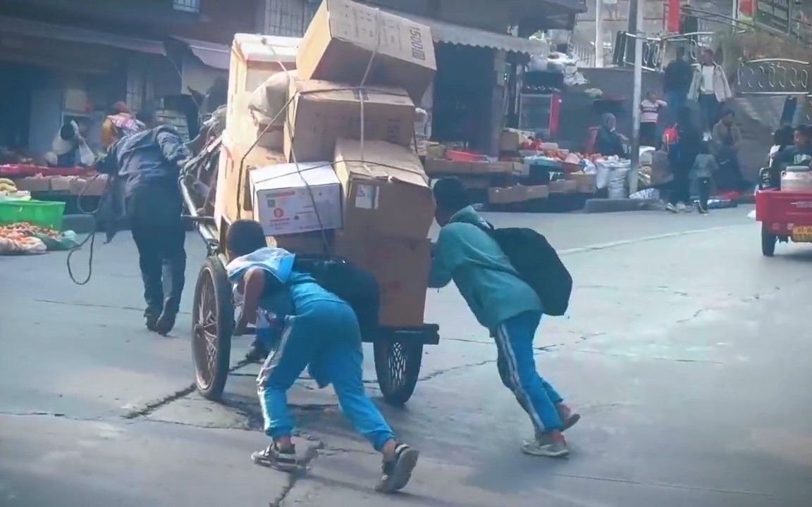 残疾大叔推车艰难上坡,2小男孩立马助力,学校予以全校通报表扬!