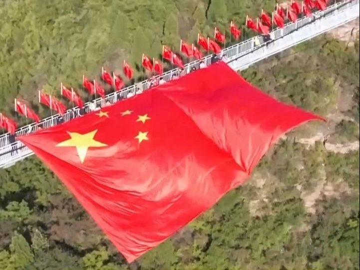 百余名游客手托20米国旗为祖国送祝福