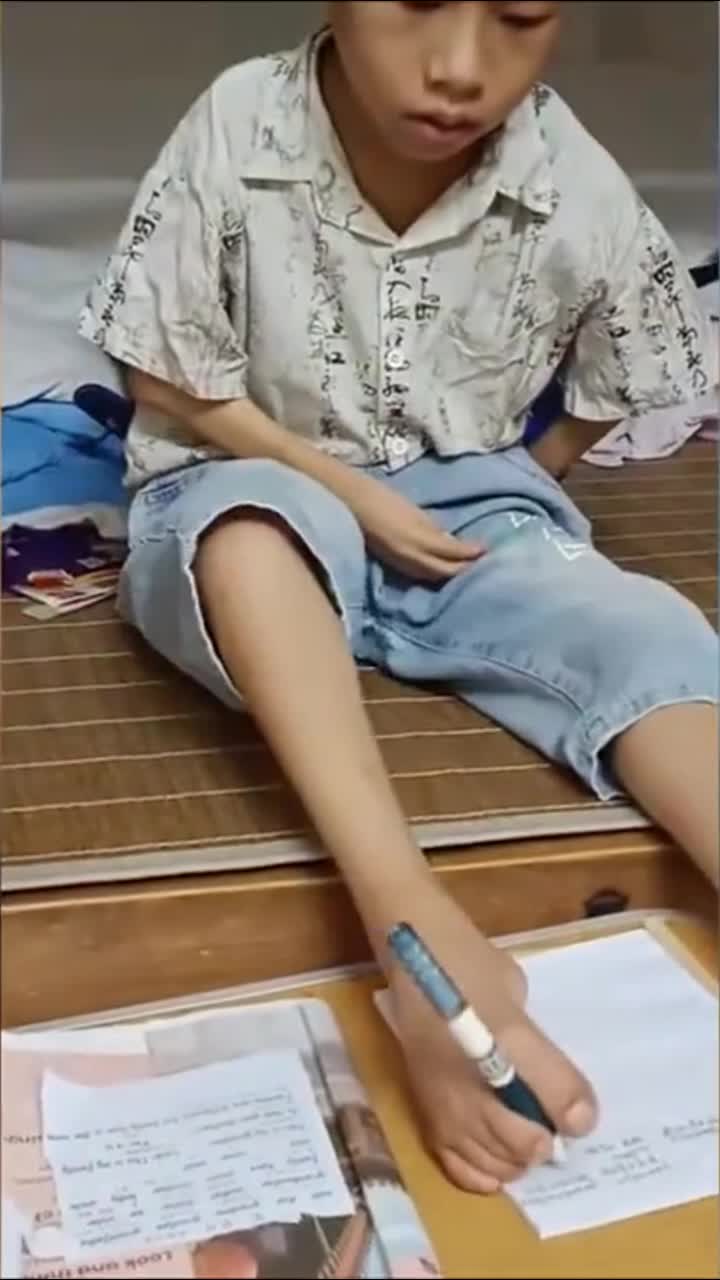 身残志坚!8岁残疾男孩学会用脚写字 心疼妈妈主动做家务