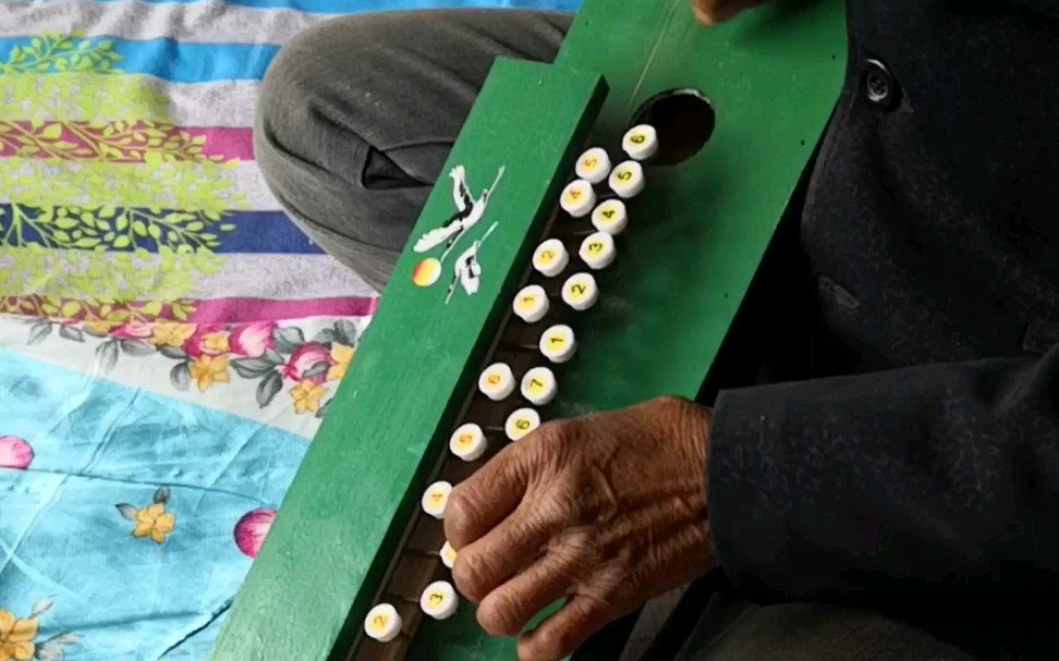 奶奶在老家弹凤凰琴绣金匾