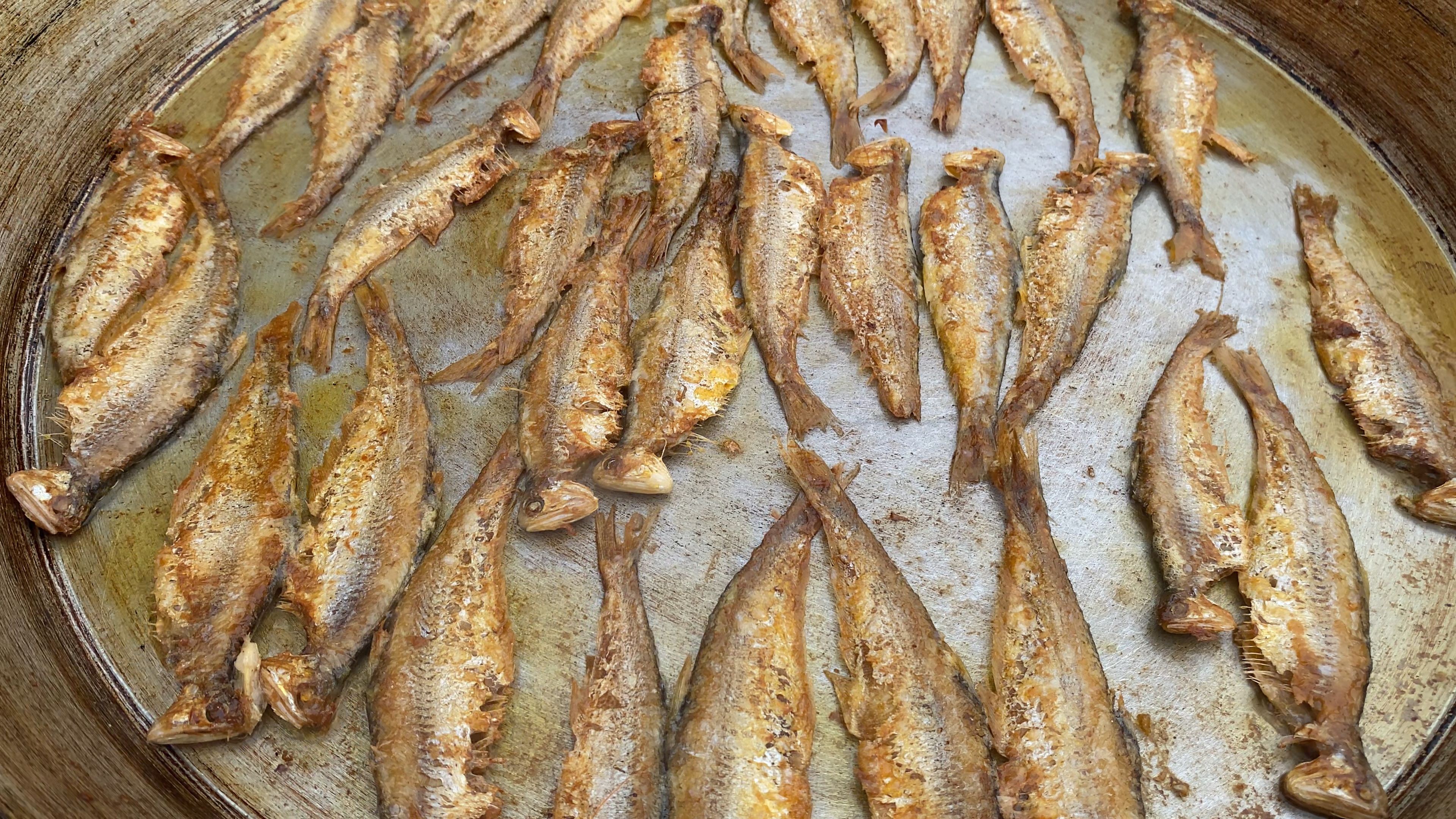 青岛街头炸小海鱼,不知道什么鱼,1元一条,游客慕名来吃,很受欢迎