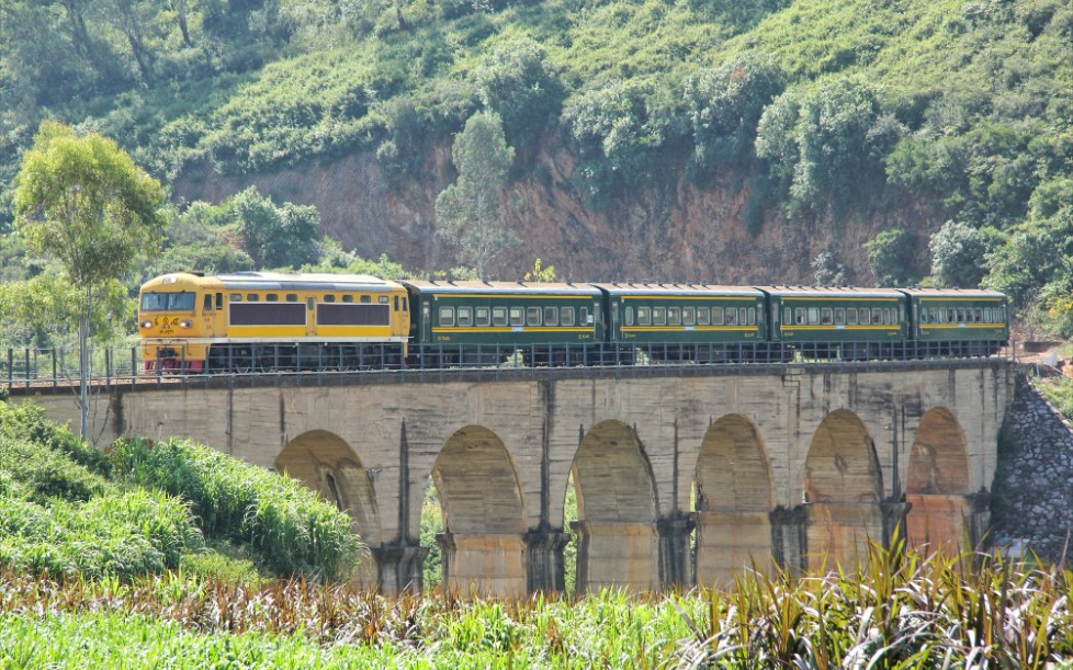 中国铁道昆河铁路东风210008牵引米轨客车57302行驶在玉林山中520存货