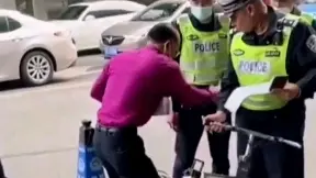 大爷骑着小电动车到十字被交警拦下，说是违规要扣车，你扣车电池不给
