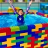 外国小女孩在妈妈的帮助下，居然用积木玩具搭成了一座正方形的游泳池哦~