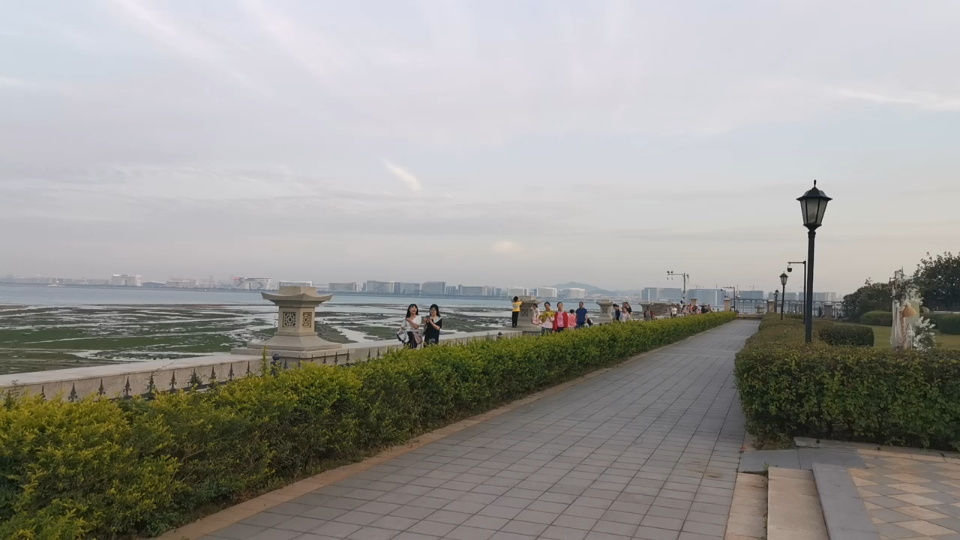 厦门北海湾惠龙万达嘉华酒店边的海滩,游人在逮螃蟹,对面是集美大桥