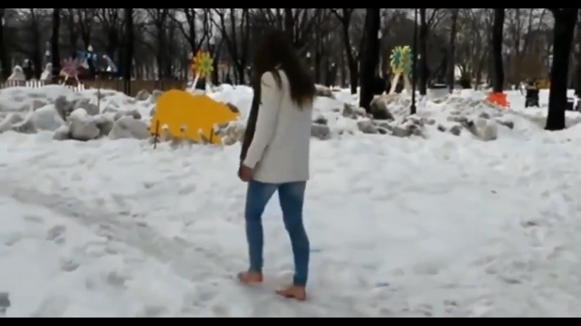 女生光脚踩在寒冷的雪地里