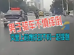 Descargar video: 男子骑车在机动车道不慎摔倒，交警上前搀扶却不料下一秒一起摔倒