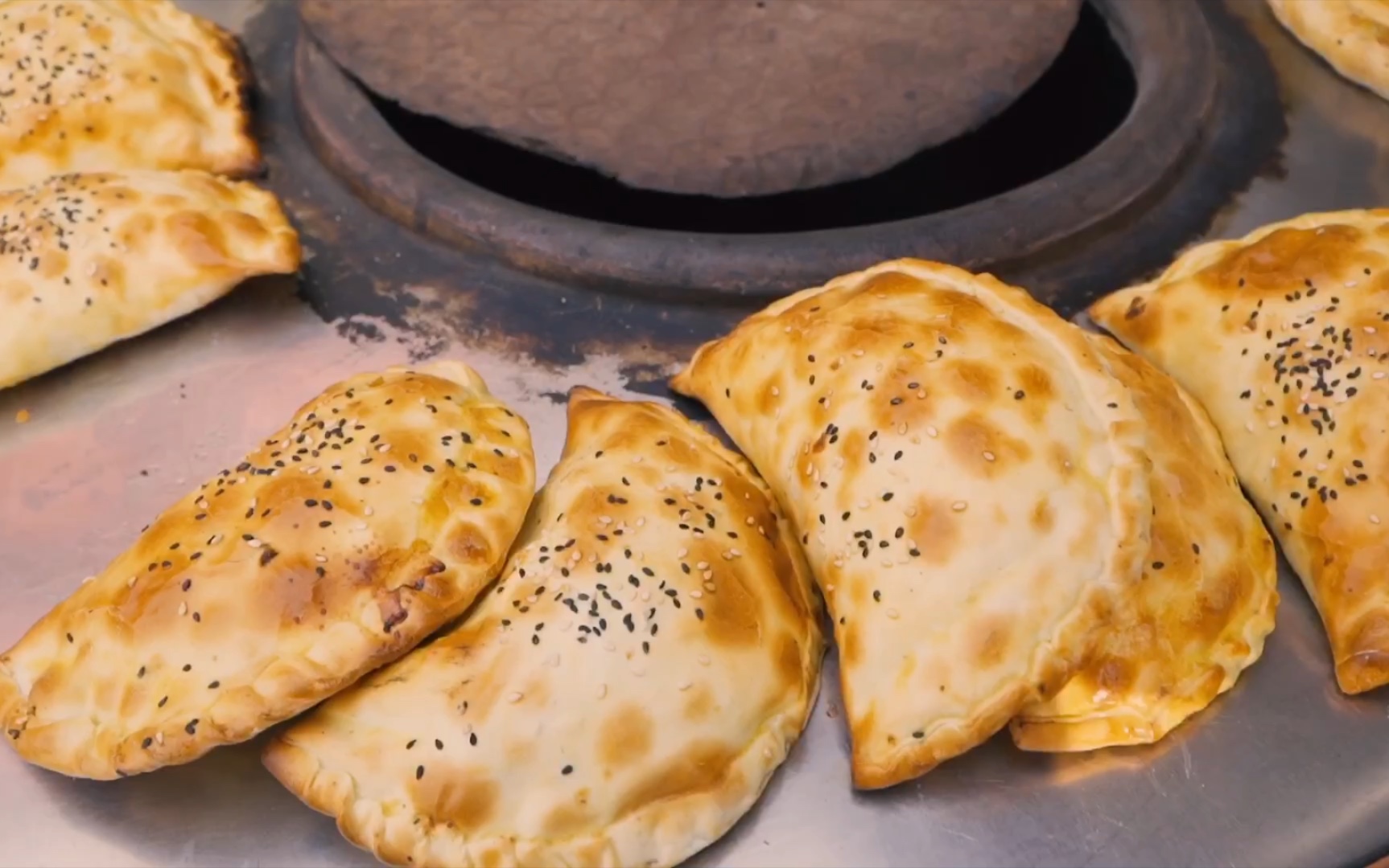 新疆烤包子的爷爷烤肉包6元个装满羊肉皮芽子一天能卖出100个