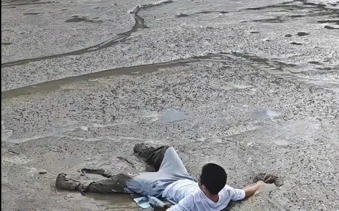 男孩不慎陷入泥潭