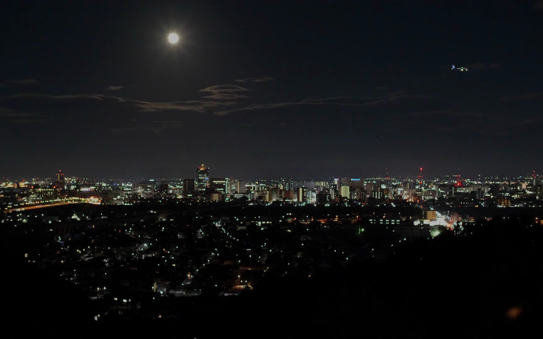 在kureha山观景台看富山城市夜景灯光 飞机飞过 天空中的月亮