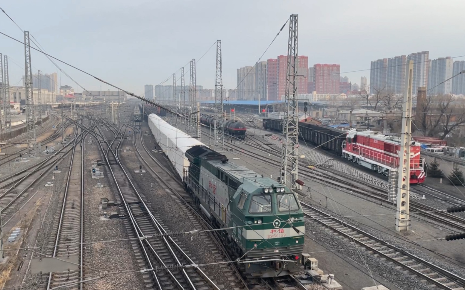 装箱编组的货物列车鸣电笛通过哈局哈段df7g5515牵引25g客车推进通过