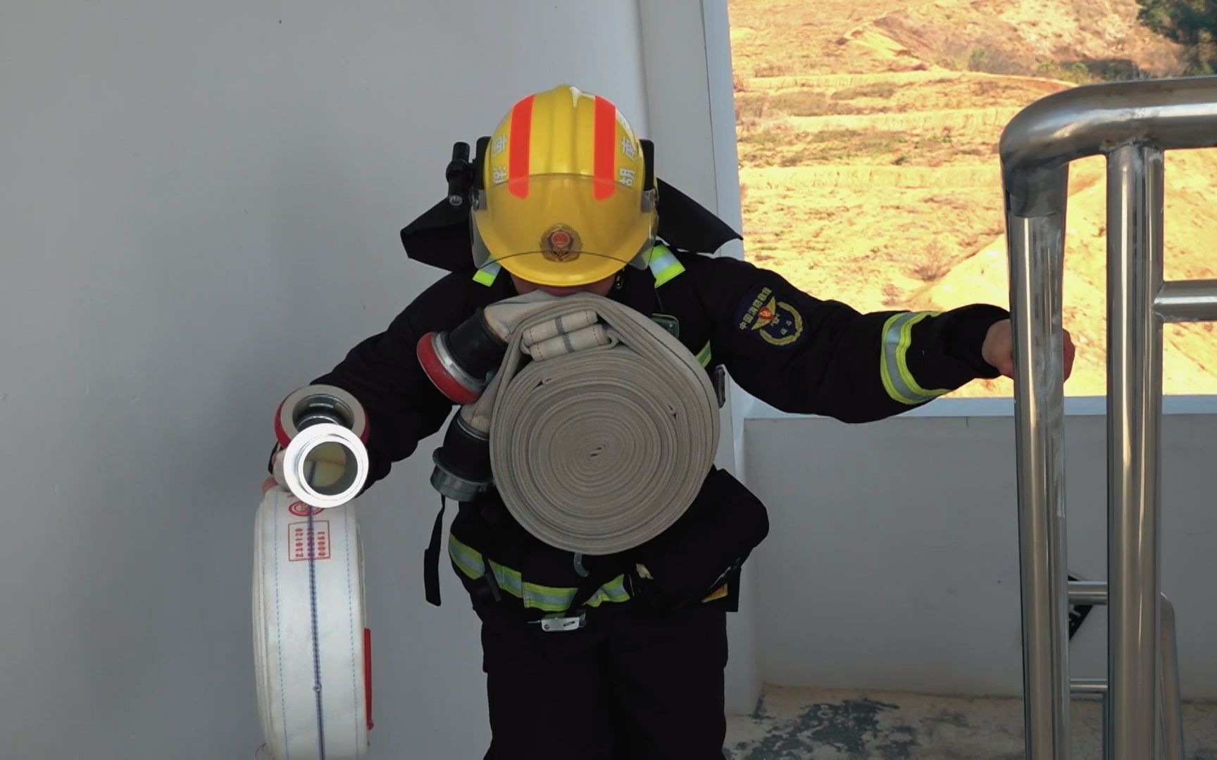 消防员用嘴叼水枪带进行训练