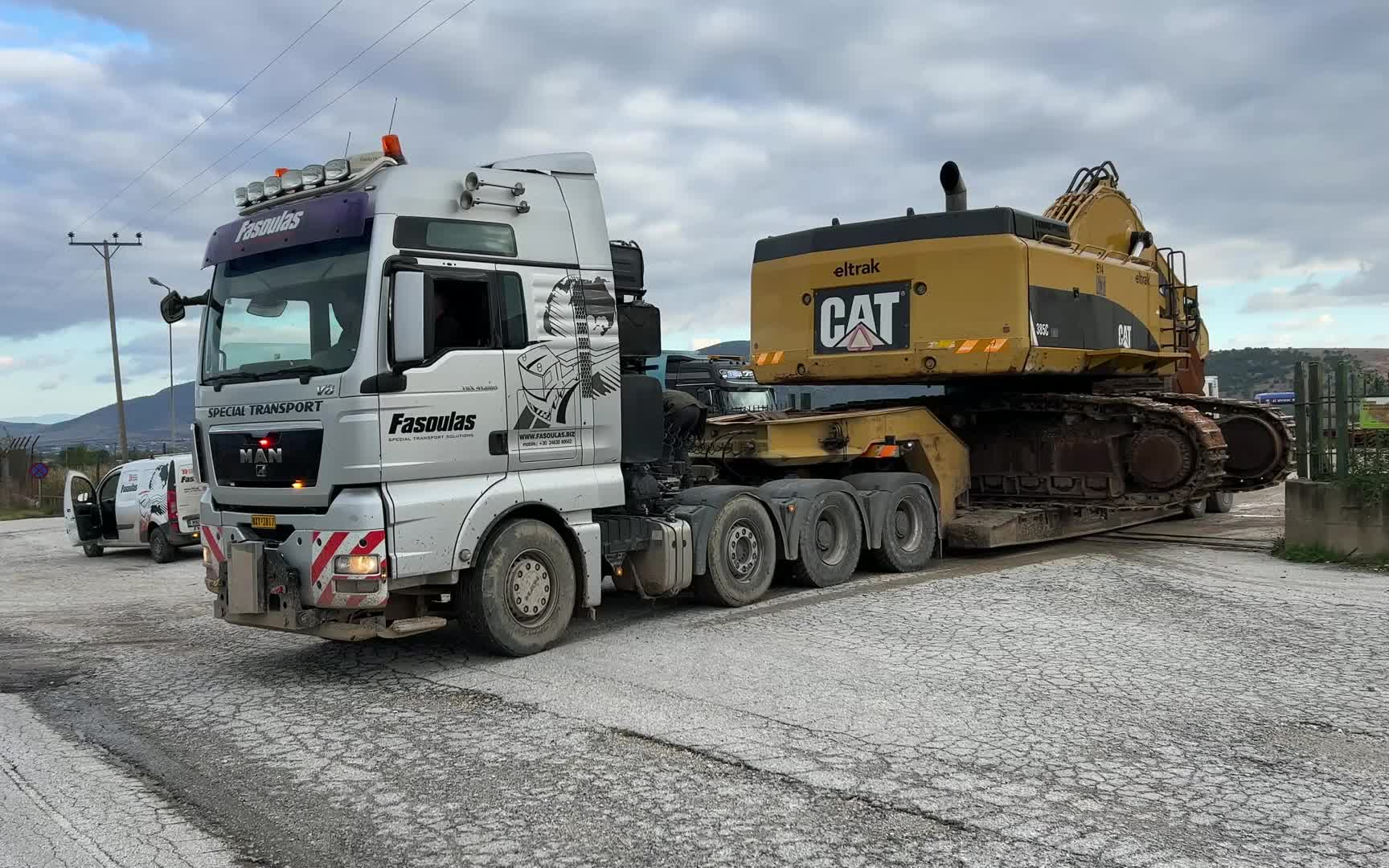 法苏拉斯重型运输车队的man-tgx侧面装载和运输卡特彼勒385c挖掘机