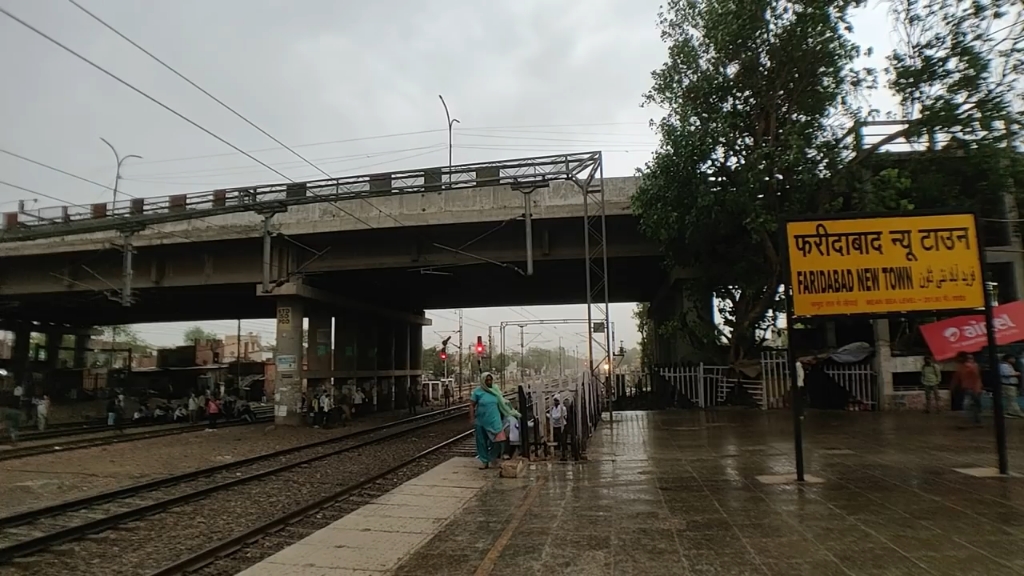 印度火车站的混乱景象,行人们乱窜,火车通过时,尘土和垃圾到处飞扬.