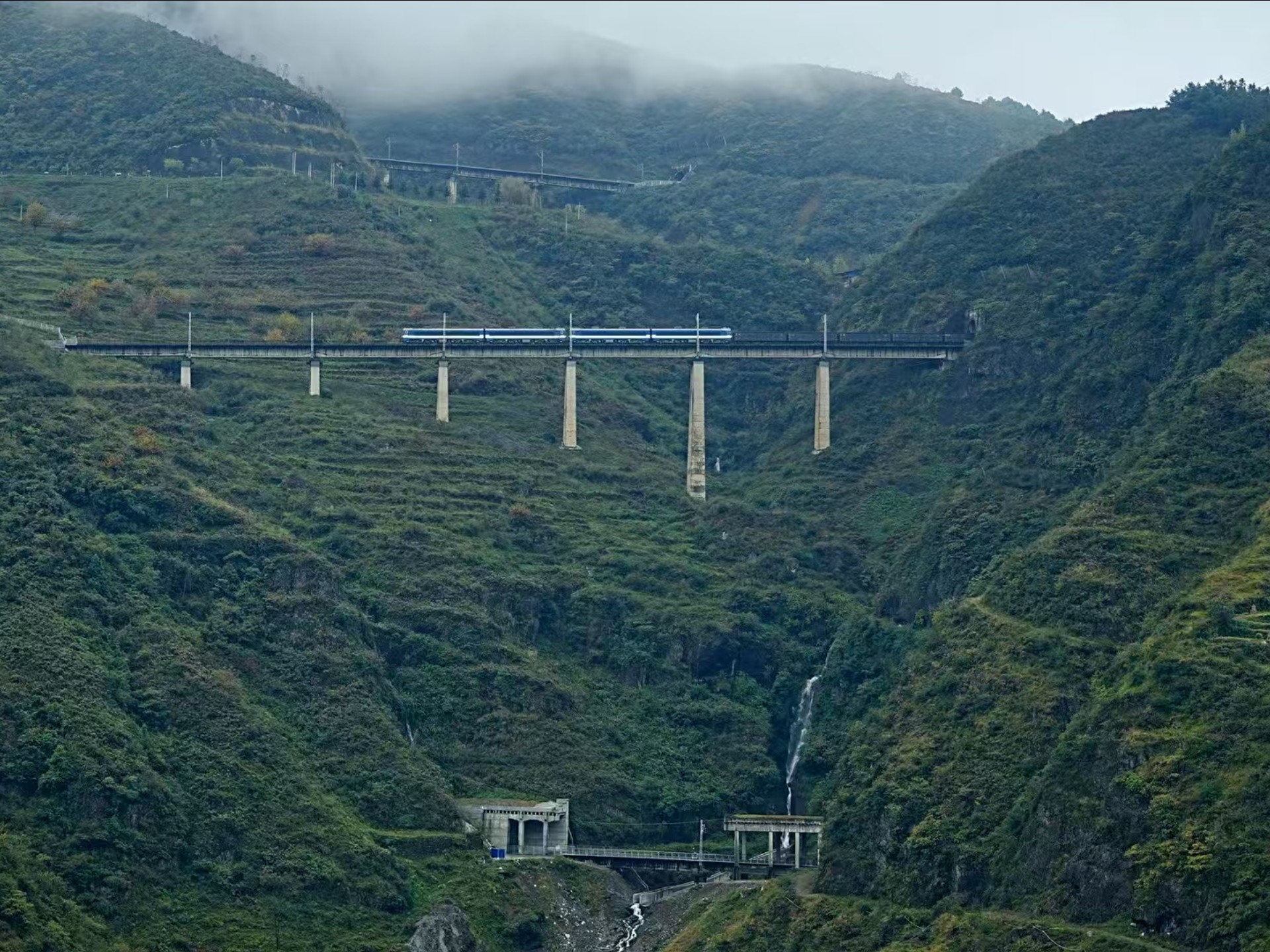 云南昭通看双机韶山3b牵引列车通过云雾环绕的彝良展线