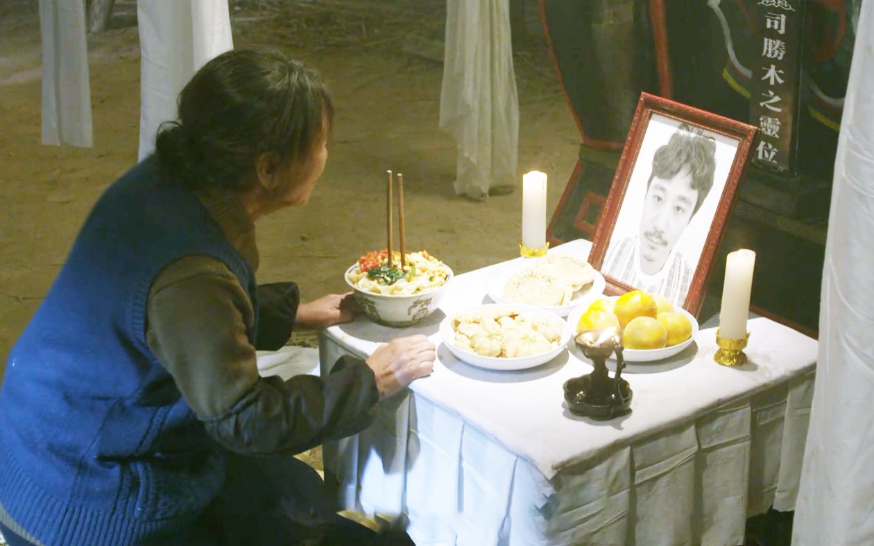 小伙回家给母亲奔丧,却在灵堂发现自己遗像,母亲还在给他烧纸