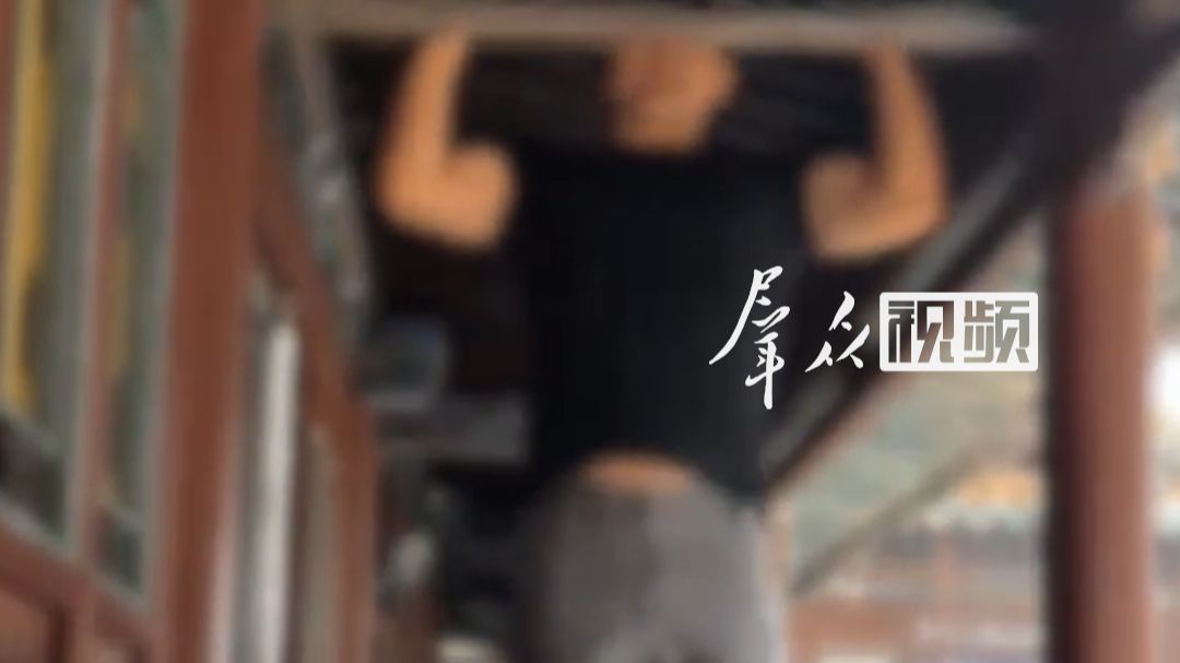 男子在千年古建横梁做引体向上，悬空寺珍贵构件被当健身器材。景区：已接到举报正在核实上报。