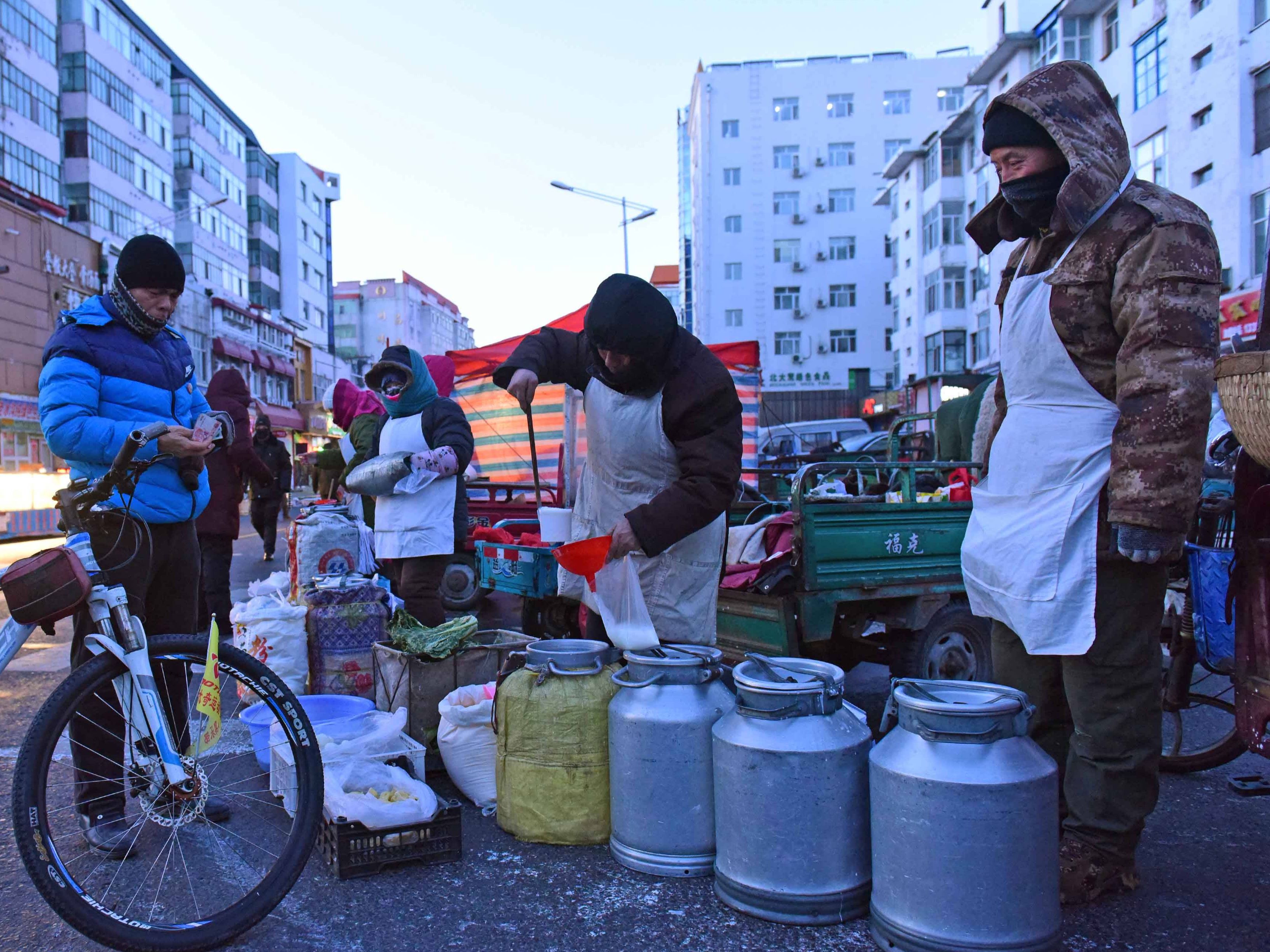 哈尔滨大有坊早市 零下21度的街市上人流如织 烧炭加温卖活鱼 三口