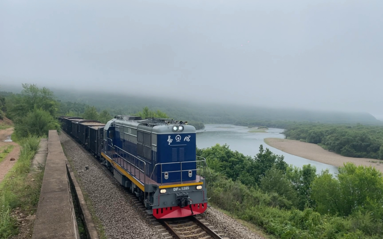哈局齐段df7c5385牵引五辆矿车五辆敞车编组的货物列车通过弯道接近嫩
