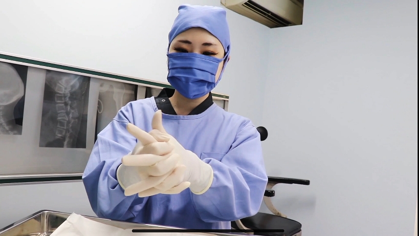 护士戴好手套后协助主治医生戴手套