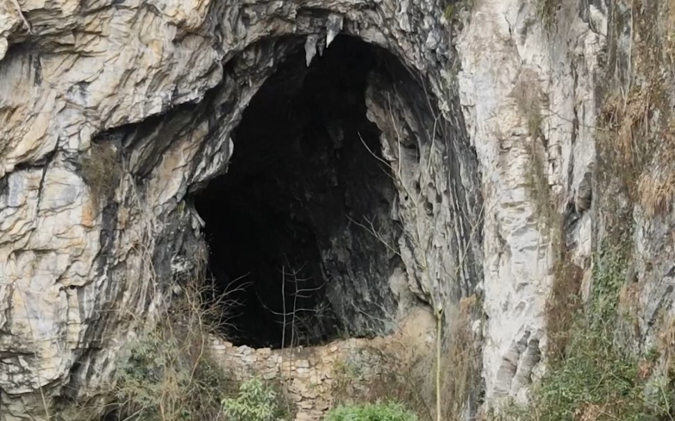 贵州深山拍到神秘山洞,洞口有一堵石墙,上面还放着一把椅子,有施工过