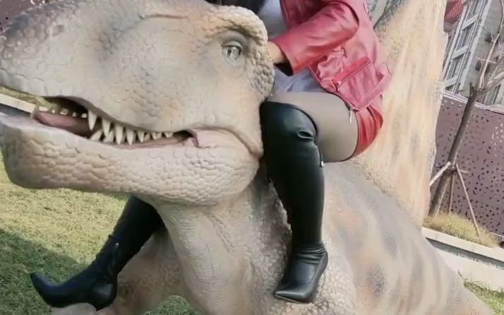 妹子穿皮靴踩恐龙的爪并骑上去
