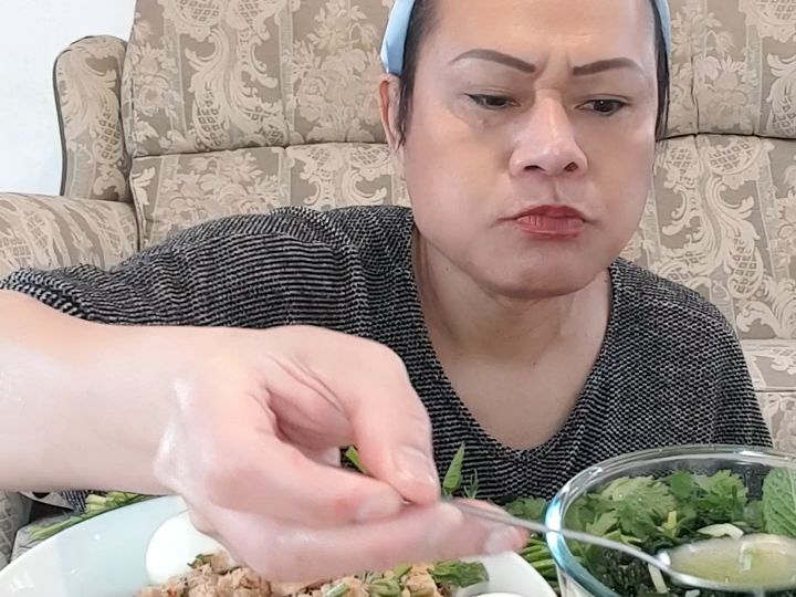 泰国人妖珍妮吃泰式鱼肉沙拉配上蔬菜绿化带