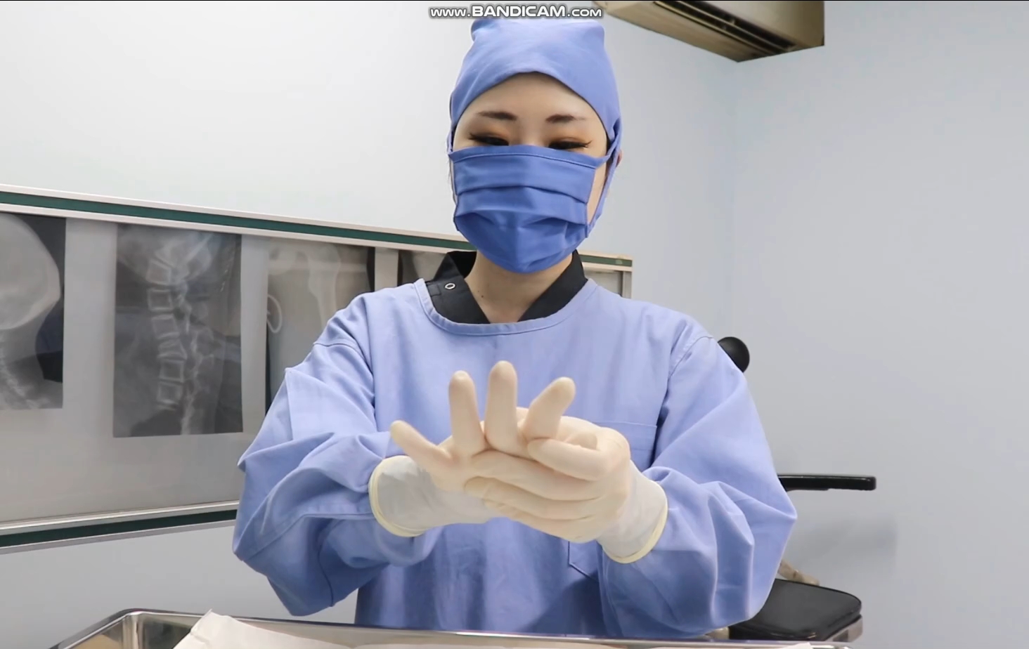 女护士辅助女医生戴好手术手套,准备做手术啦!